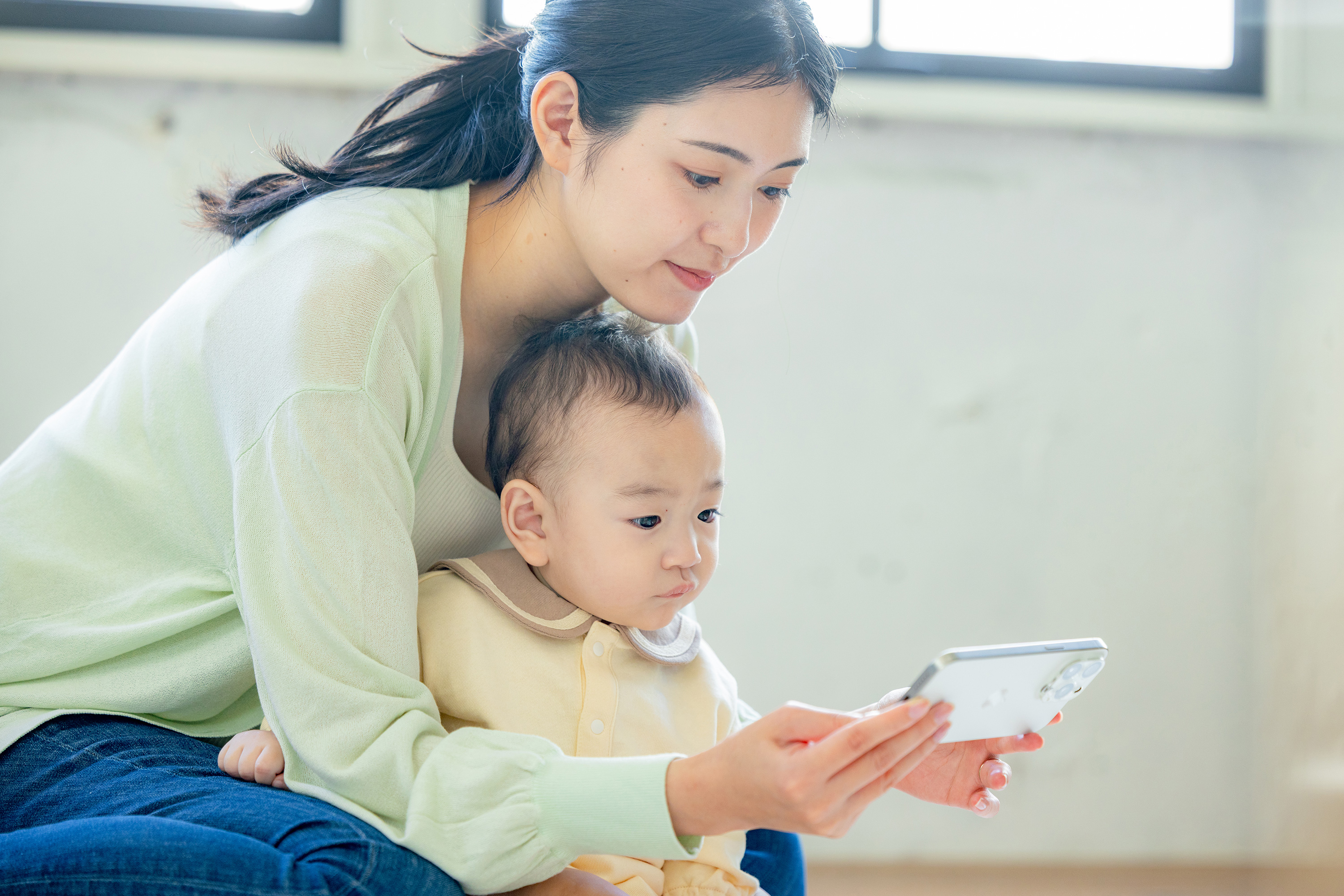 スマートフォンで来客を確認する親子